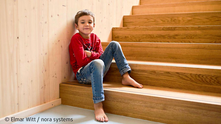 Kind sitzt auf nachhaltigem und wohngesundem Boden von nora