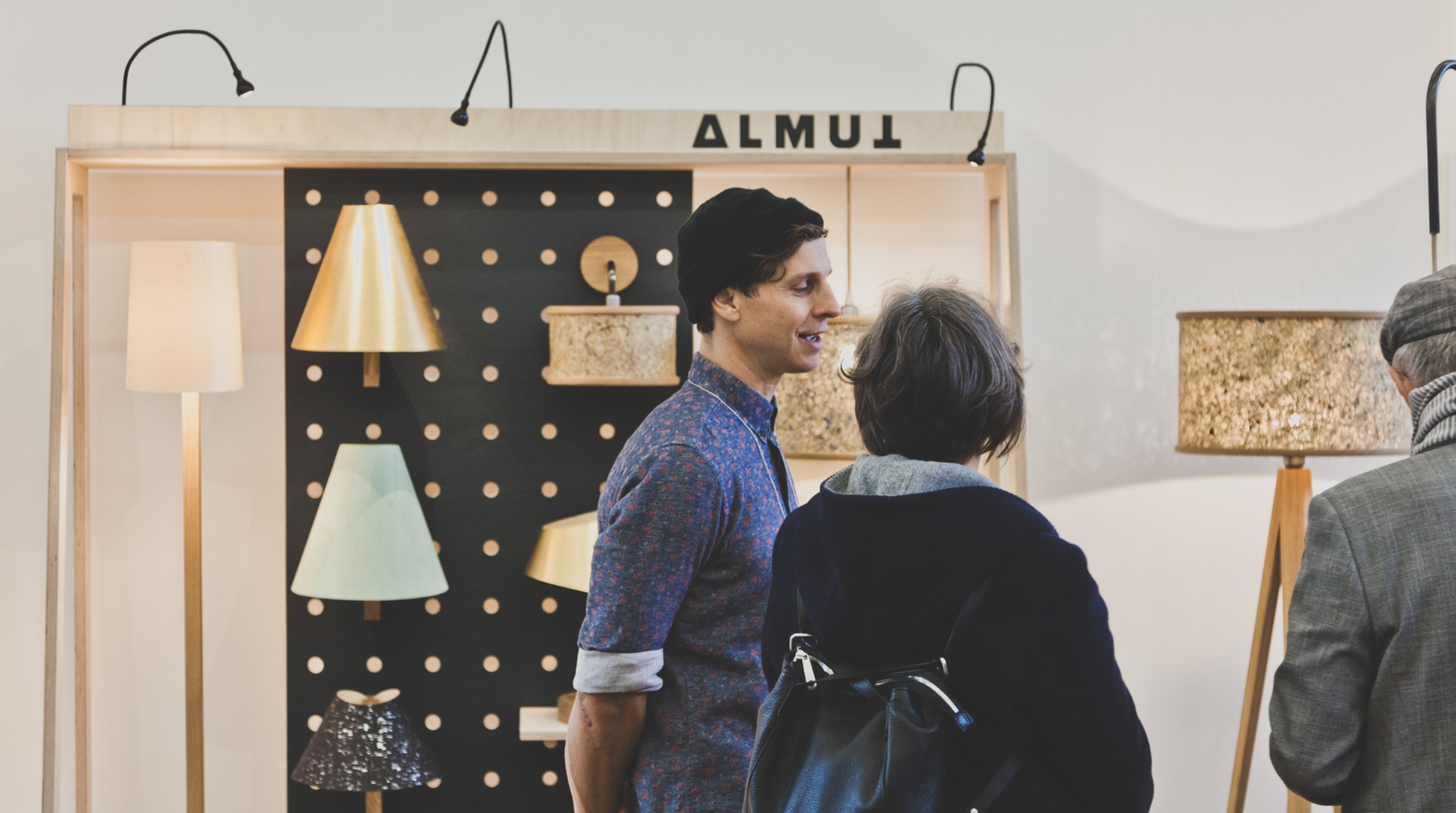 Der Showroom von ALMUT von Wildheim, mit Ulrich Huber und Kunden im Gespräch. Im Hintergrund sind Lampen zu sehen 