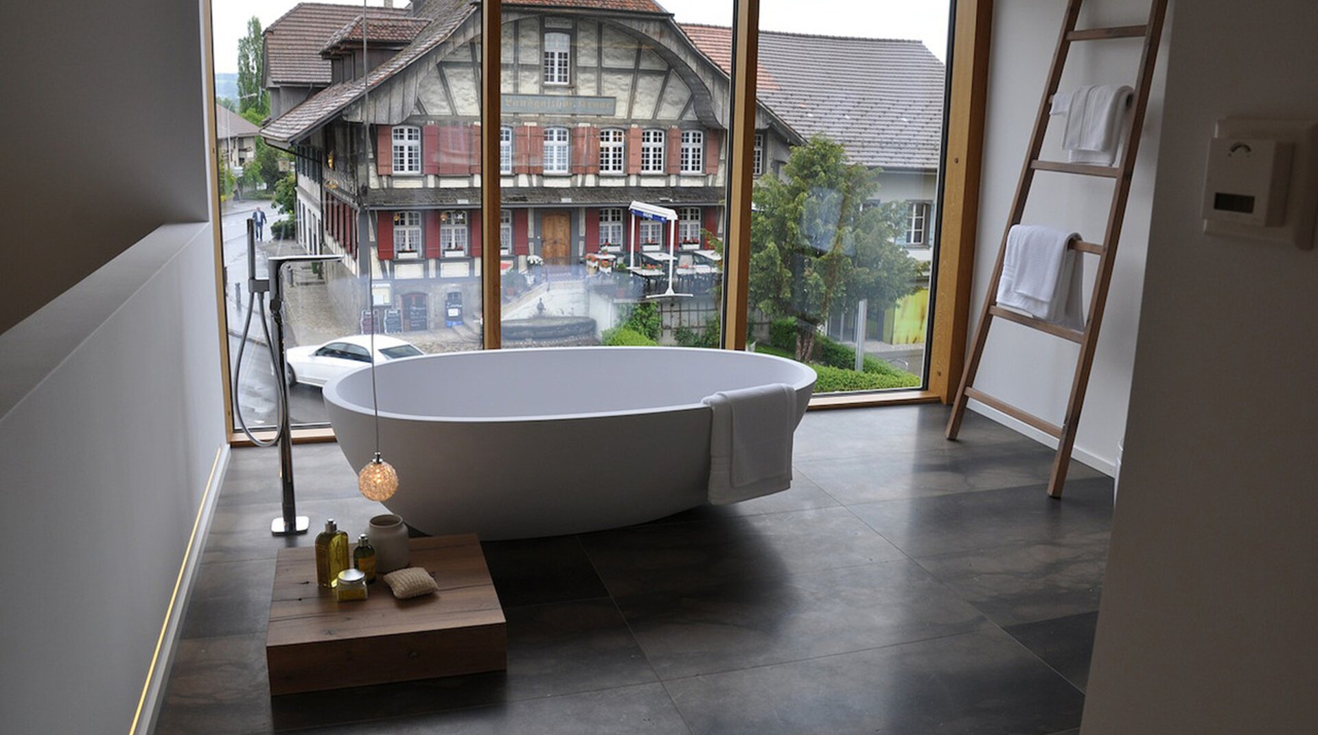 Utendorf, Badezimmer, Badewanne freistehend, Hintergrund durch bodentiefe Fenster Blick auf gegenüberliegendes Fachwerkhaus