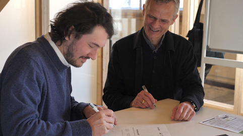 Julius Schäufele, CEO von Concular, und Peter Bachmann, Geschäftsführer Sentinel Haus Institut, unterzeichnen die Kooperationsvereinbarung.