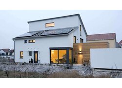 Haus, Sicht vom Garten auf Aussenfassade in das Innere des Hauses, Solarpanele auf dem Dach