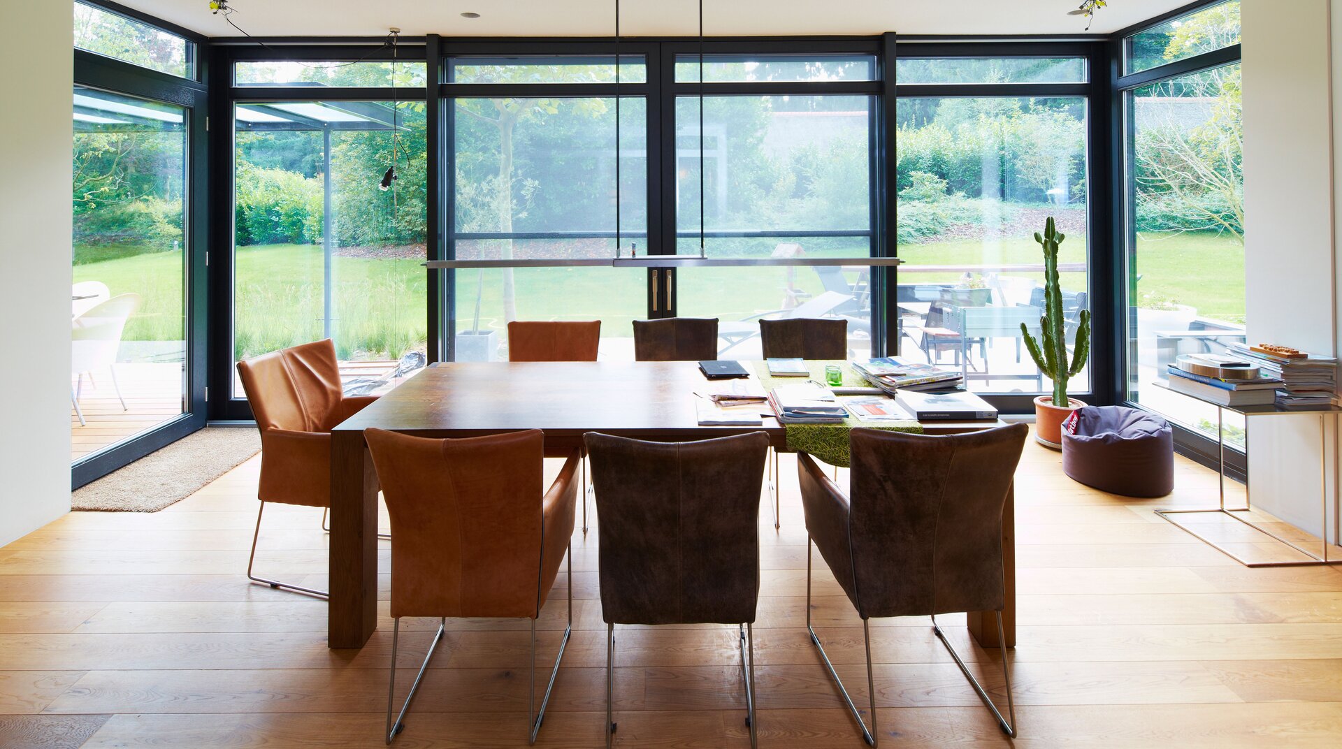 Esszimmer mit Tisch und Glasfront über zwei Ecken