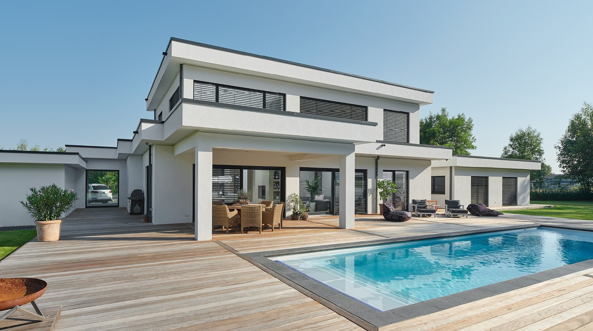 Flachdach 300 LUXHAUS Vertrieb GmbH & Co. KG, weißes Haus mit Flachdach, hinter Pool