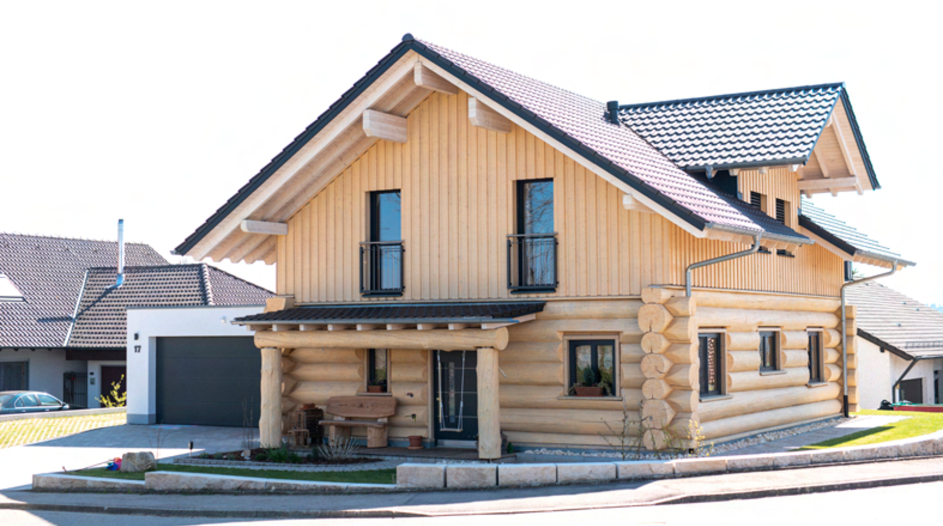 Blockhaus mit Garage und Vordach, von vorne fotografiert, helles Holz